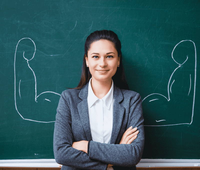 Frau steht vor Schultafel